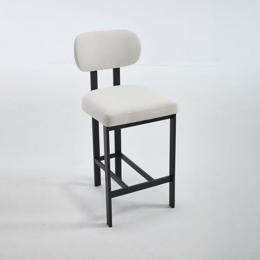 Two beige fabric counter height stools with black metal legs at a compact kitchen counter
