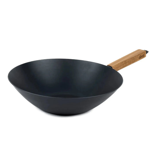 12-inch pre-seasoned carbon steel flat-bottom wok with wooden handle on a kitchen stovetop